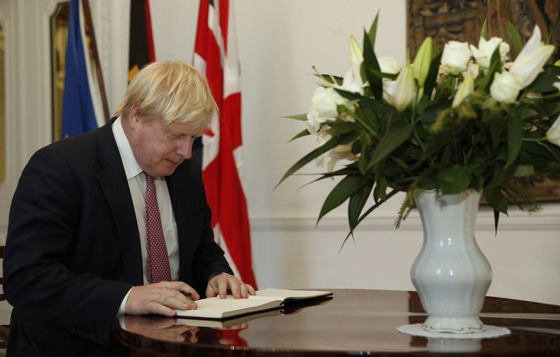 © Reuters. Britain's Foreign Secretary Boris Johnson signs a book of condolence for victims of the Berlin truck attack, at the German embassy in London