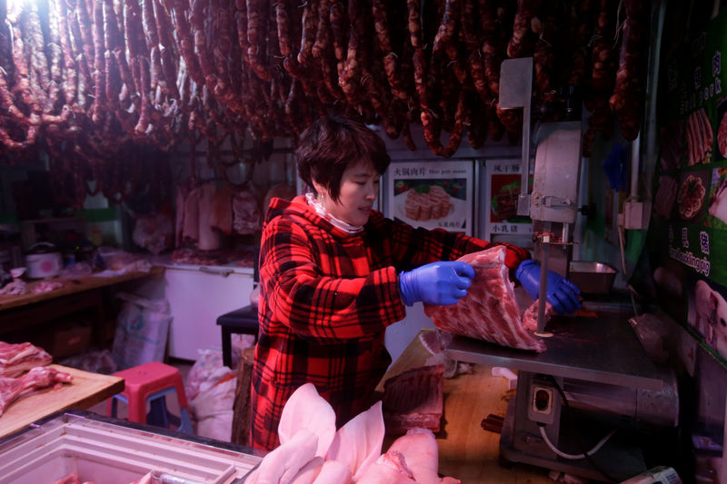 © Reuters. A vendor prepares meat at a market in Beijing