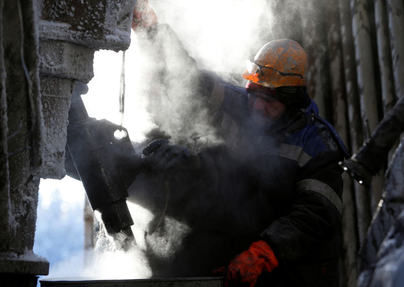 © Reuters. FILE PHOTO: Employees work on drilling rig at Rosneft company owned Samotlor oil field outside West Siberian city of Nizhnevartovsk