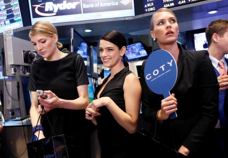 © Reuters. Models gather at a trading post on the floor of the New York Stock Exchange for the IPO of Coty Inc.