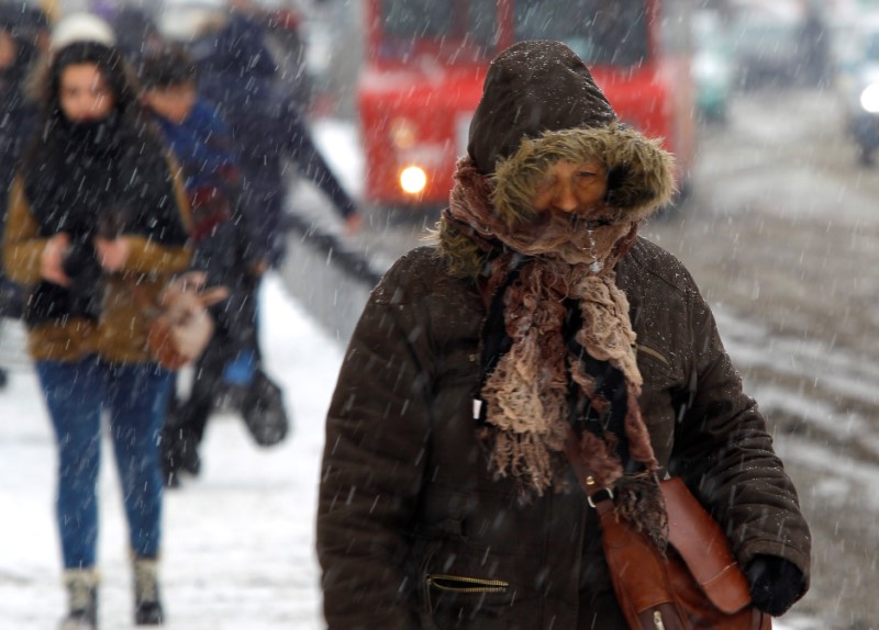 © Reuters. A woman walks in a snowstorm in Skopje