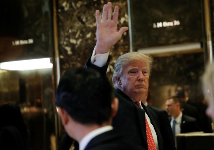 © Reuters. U.S. President-elect Donald Trump waves to people in the lobby after appearing with Alibaba executive chairman Jack Ma after their meeting at Trump Tower in New York