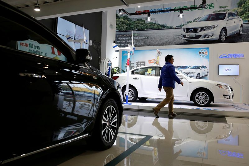 © Reuters. A man walks at an electric car dealership in Shanghai