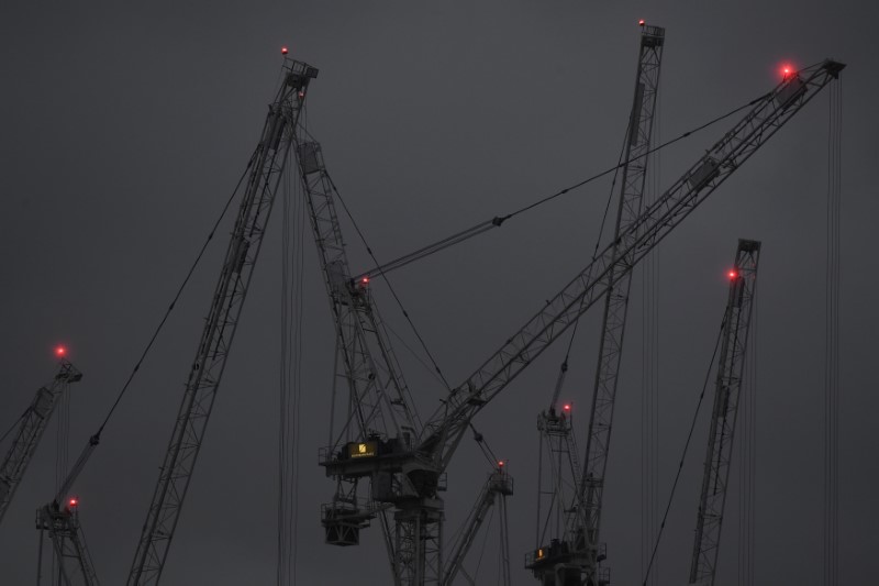 © Reuters. Construction cranes are seen at dusk on a grey day in London, Britain