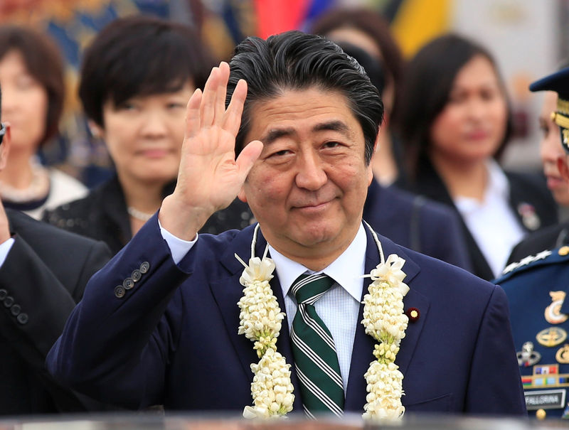 © Reuters. Japanese Prime Minister Shinzo Abe waves upon arrival for a state visit in metro Manila, Philippines