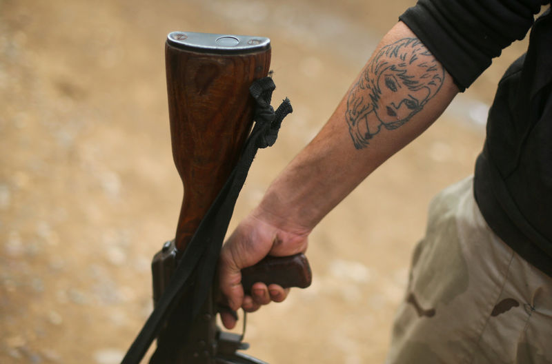 © Reuters. A tattoo is pictured on the arm of an Iraqi fighter in Namrod village