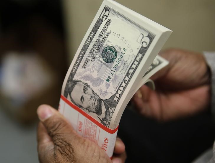 © Reuters. Pacote de notas de cinco dólares dos Estados Unidos passam por inspeção em Washington, nos EUA