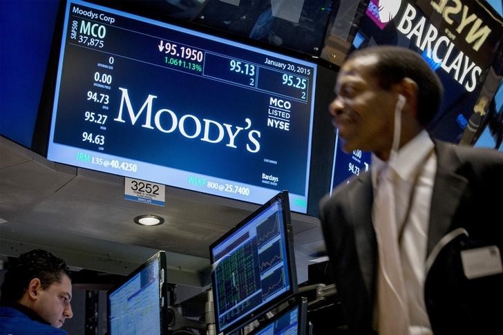 © Reuters. A screen displays Moody's ticker information as traders work on the floor of the New York Stock Exchange