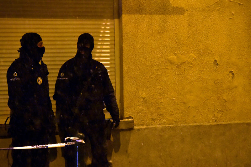 © Reuters. Belgian police officers stand guard at the scene of a security operation in the Brussels district of Molenbeek