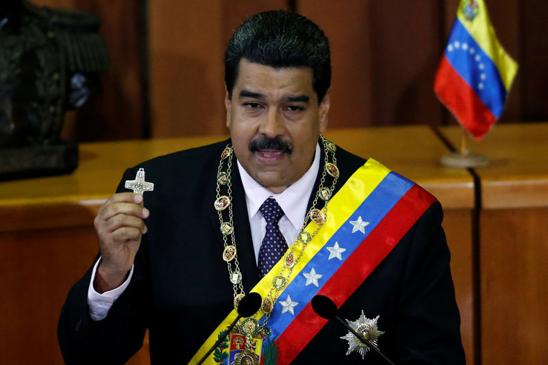 © Reuters. Venezuela's President Nicolas Maduro holds a crucifix as he speaks during his annual report of the state of the nation at the Supreme Court in Caracas