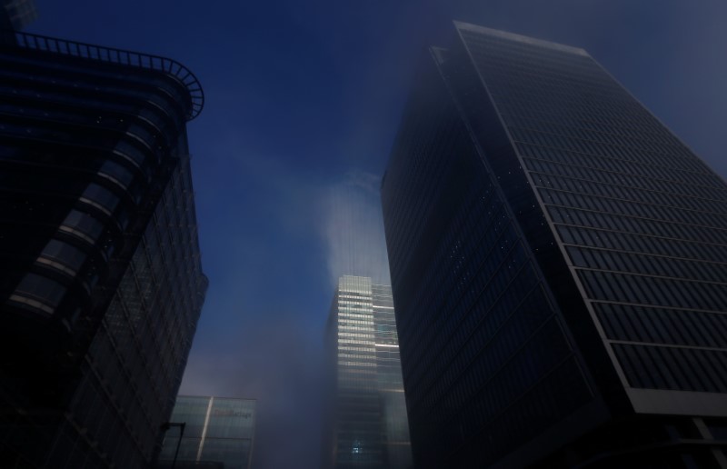 © Reuters. Sunlight reflecting off a building is seen during a foggy morning in the Canary Wharf financial district of London