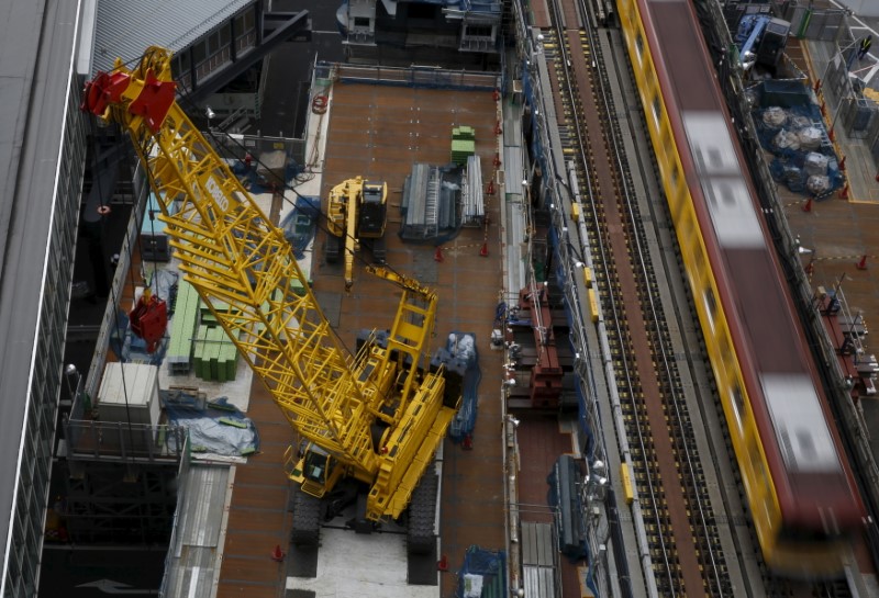 © Reuters. Heavy machineries are seen next to a subway train at a construction site in Tokyo