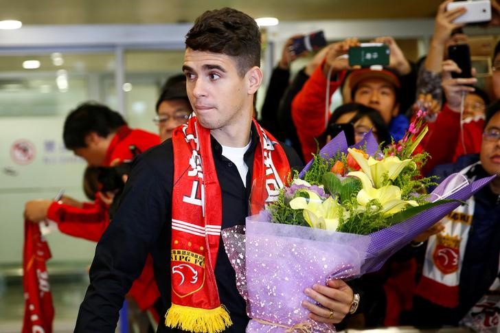 © Reuters. Brazilian international midfielder Oscar arrives at the Shanghai Pudong International Airport, after agreeing to join China super league football club Shanghai SIPG from Chelsea in Shanghai