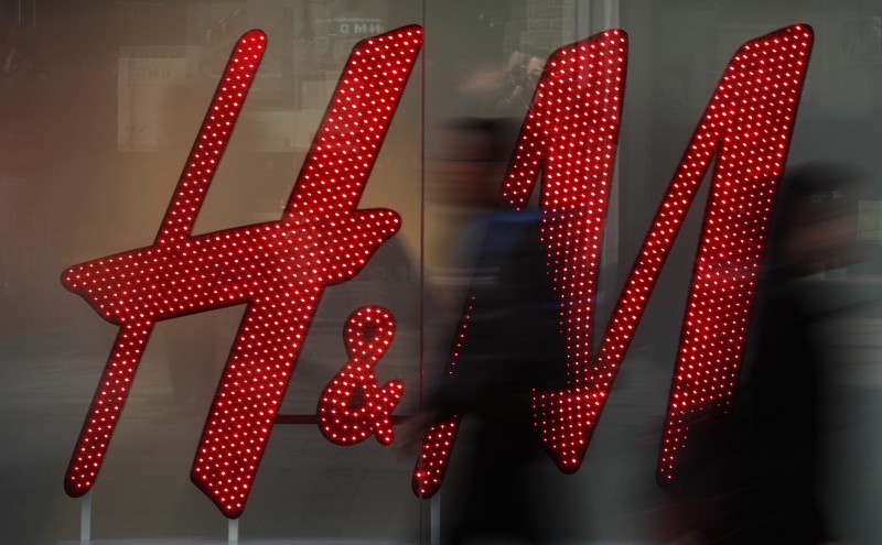 © Reuters. People walk past a company logo in the window of a H&M store in Manchester northern England