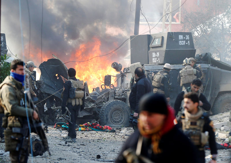 © Reuters. Iraqi Special Operations Forces (ISOF) react after a car bomb exploded during an operation to clear the al-Andalus district of Islamic State militants, in Mosul