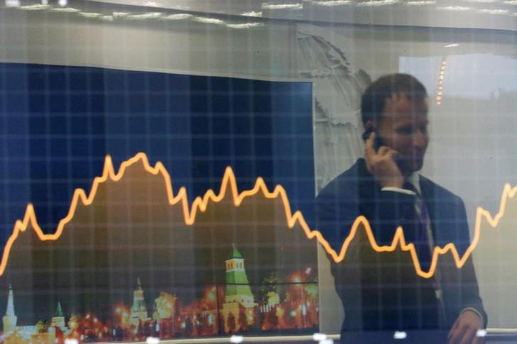 © Reuters. Отражение участника инвестфорума ВТБ Капитал "Россия зовет!" в экране с финансовой и деловой информацией