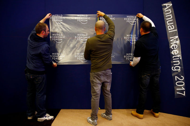 © Reuters. Workers prepare the logo of the World Economic Forum in the congress center of the annual meeting of the World Economic Forum (WEF) in Davos