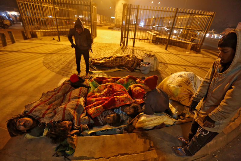© Reuters. A family gather under blankets to shelter from the cold beneath a flyover in Delhi