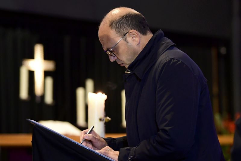 © Reuters. Italian FM Alfano signs a condolence book in Berlin