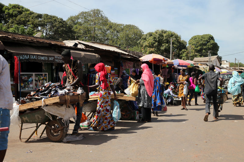 © Reuters. Women make purchases at the serecunda market moments before the president declared a State of Emergency in Banjul