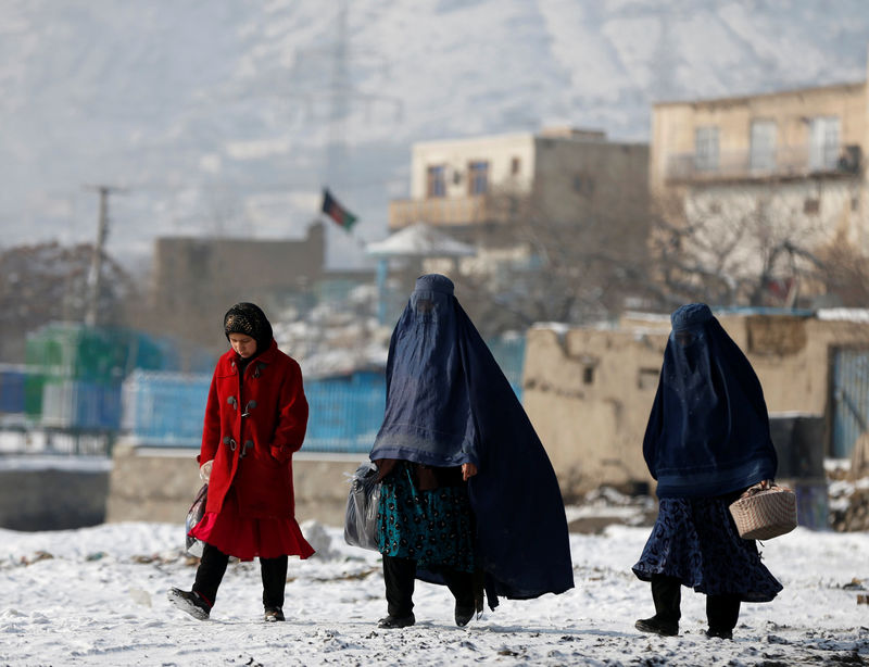 © Reuters. Women walk along a street in Kabul