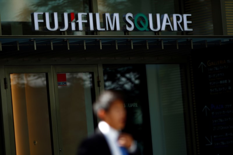© Reuters. A man stands in front of the headquarters of Fujifilm Holdings Corp in Tokyo
