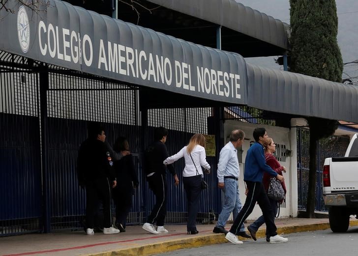 © Reuters. Estudantes saem de escola com adultos no México após tiroteio