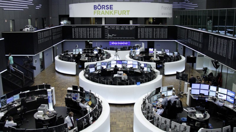 © Reuters. Traders work at their desks in front of the German share price index DAX board in Frankfurt