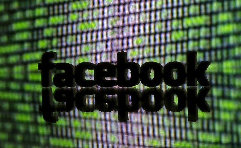 © Reuters. 3D printed Facebook logo is seen in front of a displayed cyber code