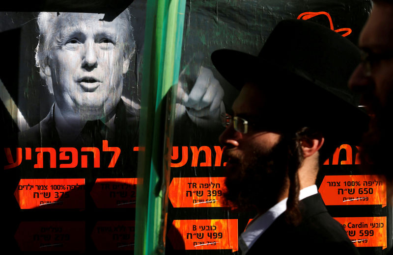 © Reuters. FILE PHOTO: Ultra-Orthodox Jewish man walks next to a poster of Donald Trump in Jerusalem's Mea Shearim neighbourhood