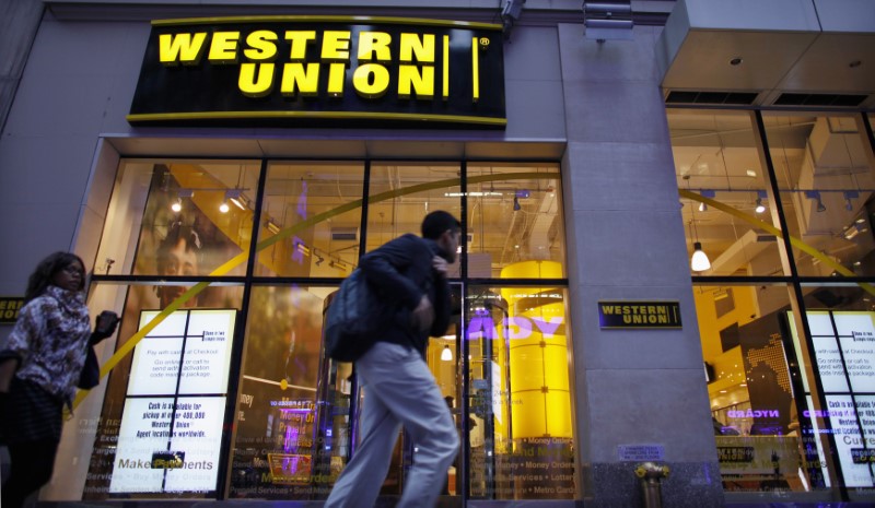 © Reuters. People walk past a Western Union branch at Times Square in New York