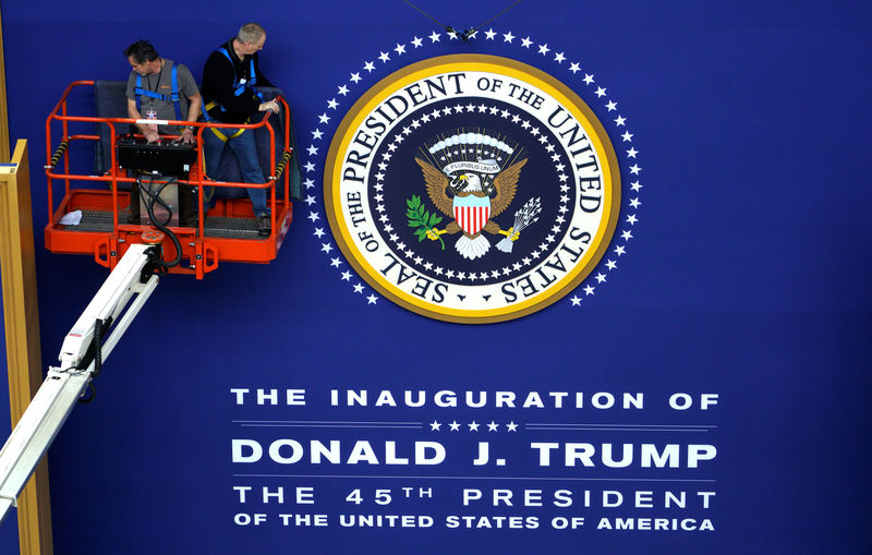 © Reuters. Workers install the presidential seal at the site of the Commander in Chief inaugural ball for President-elect Donald Trump in Washington, DC