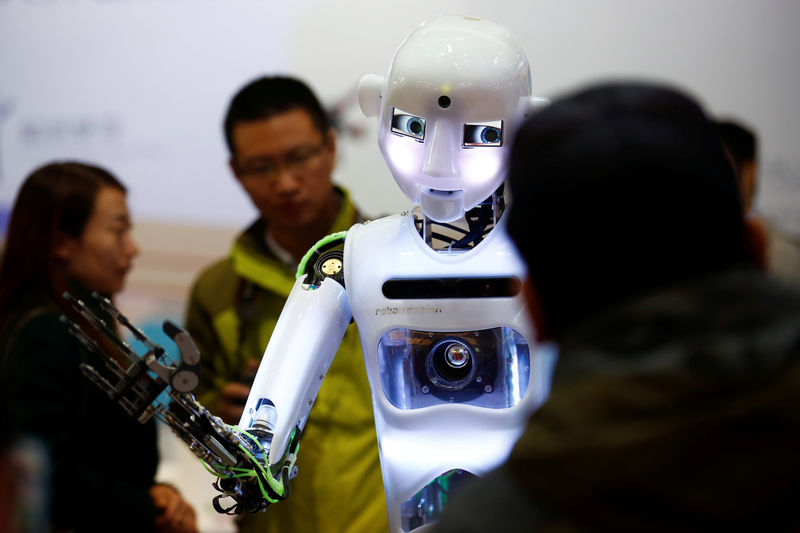 © Reuters. FILE PHOTO: People look at a humanoid robot at the Tami Intelligence Technology stall at the WRC 2016 World Robot Conference in Beijing