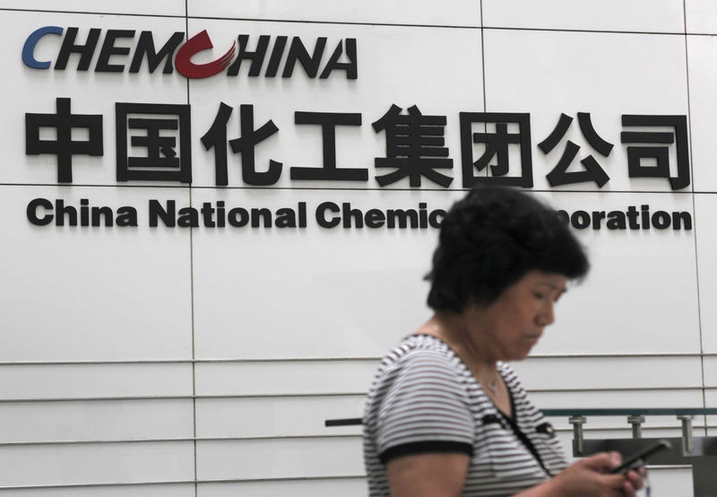 © Reuters. FILE PHOTO -  A woman checks her phone at the headquarters of China National Chemical Corporation in Beijing