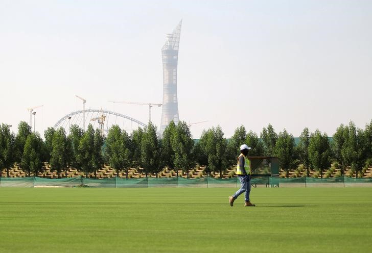 © Reuters. Worker walks on grass being grown for Qatar's 2022 World Cup, in Doha