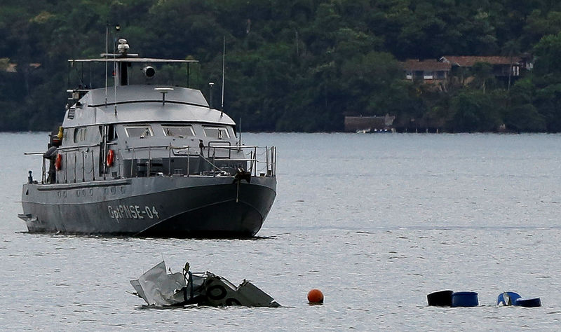 © Reuters. Navio da Marinha perto de destroços de avião que caiu no mar e matou ministro do STF em Paraty