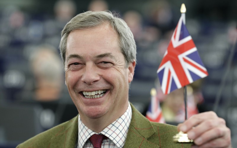 © Reuters. UKIP leader Farage and Member of the European Parliament holds a British Union Jack flag as he waits for the start of the announcement of the candidates for the election to the office of the President at the European Parliament in Strasbourg