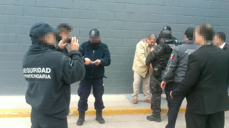 © Reuters. Mexico's top drug lord Joaquin "El Chapo" Guzman is escorted by police officers in Ciudad Juarez, Mexico, as he is extradited to New York