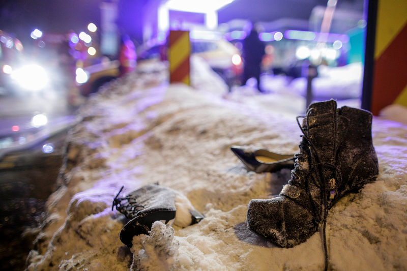 © Reuters. Lady shoes lay abandoned on the snow following the evacuation of a club after a fire broke out in Bucharest