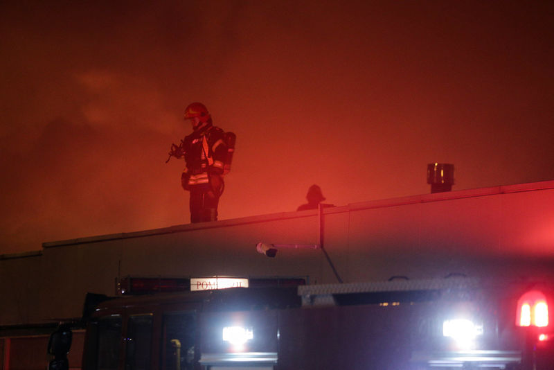 © Reuters. A firefighter works on the roof of a night club that was destroyed by a fire in Bucharest