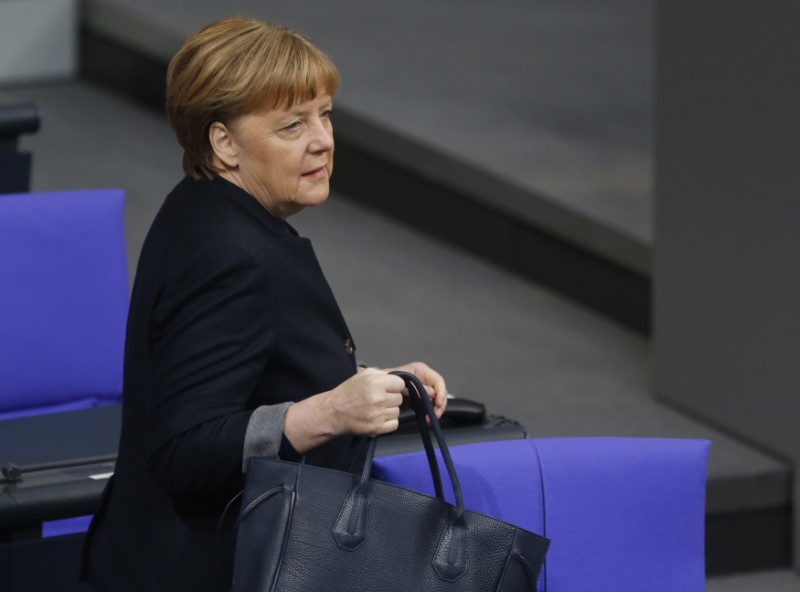 © Reuters. Chancellor Merkel walks in the Bundestag before a ceremony to commemorate victims of the Berlin truck attack in Berlin
