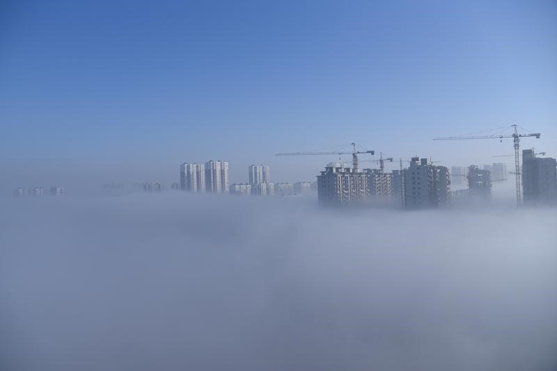 © Reuters. Buildings in construction are covered in fog in Wangdu