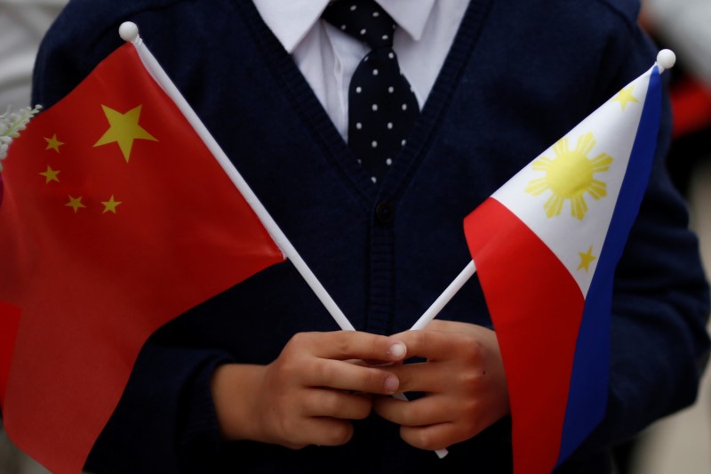 © Reuters. A child holds national flags of China and the Philippines before President of the Philippines Rodrigo Duterte and China's President Xi Jinping attend a welcoming ceremony in Beijing