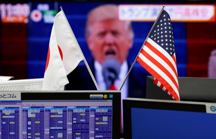 © Reuters. Флаги Японии и США напротив монитора с изображением Трампа