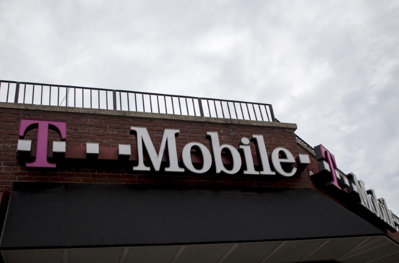 © Reuters. People pass by a T-Mobile store in the Brooklyn borough of New York