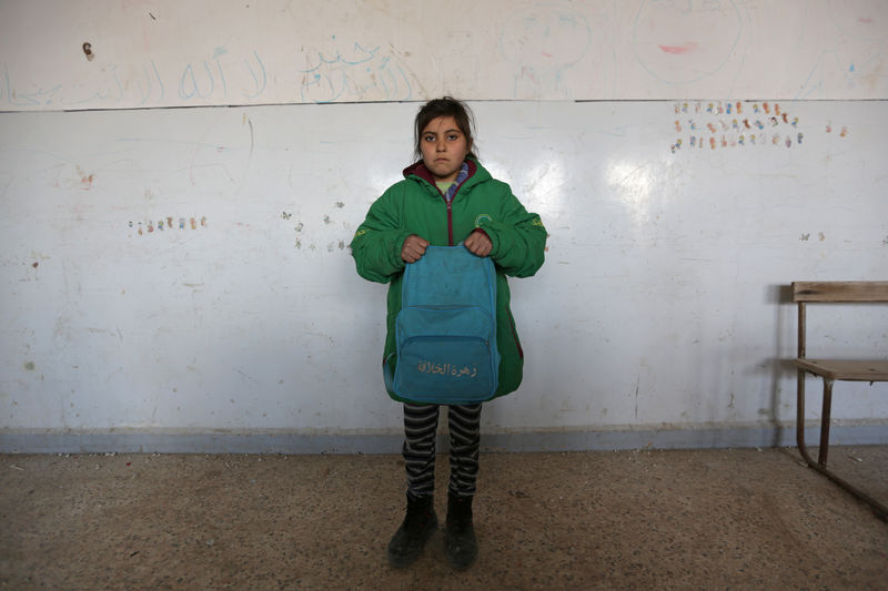 © Reuters. A student poses as she holds a Unicef-donated school bag in 'Aisha Mother of the BelieversÕ school which was recently reopened after rebels took control of al-Rai town from Islamic State militants