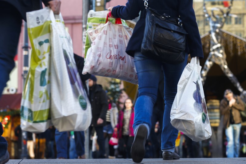 © Reuters. People carry bags outside department store on last day of Christmas shopping in Berlin