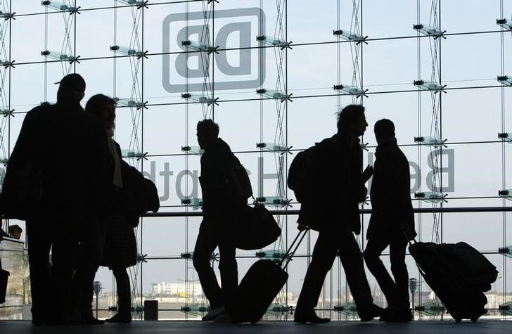 © Reuters. Commuters walk Malong a platform at Berlin's Hauptbahof railway station