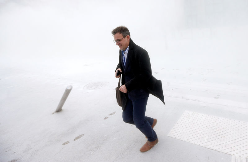 © Reuters. A man runs for cover as milk producers spray powdered milk to protest against dairy market overcapacity in Brussels