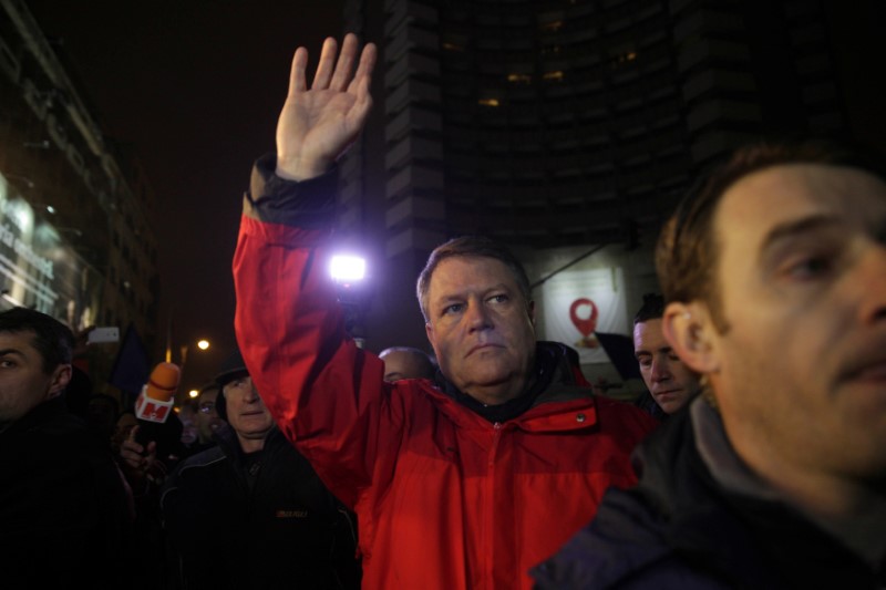 © Reuters. Romanian President Klaus Iohannis waves to protesters gathered at a demonstration against government plans to grant prison pardons and decriminalize some offences through emergency decree, in Bucharest, Romania